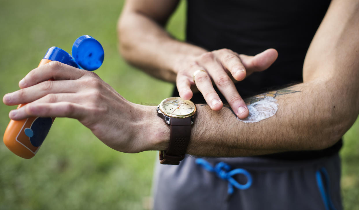 Man applying suncream to his arm