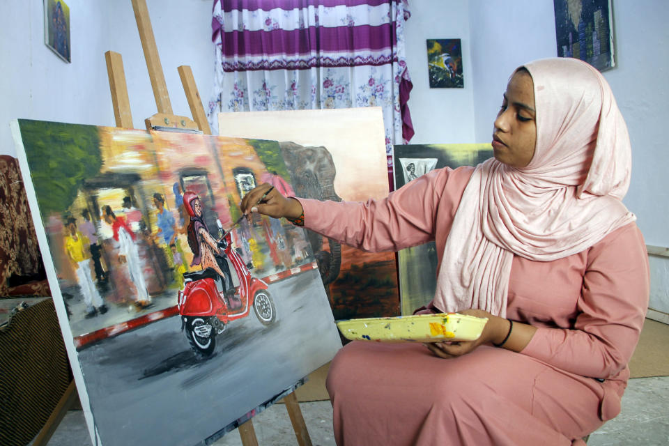 Somali artist Sana Ashraf Sharif Muhsin, 21, works on one of her paintings at her home in the capital Mogadishu, Somalia Friday, Oct. 15, 2021. Among the once-taboo professions emerging from Somalia's decades of conflict and Islamic extremism is the world of arts, and this 21-year-old female painter has faced more opposition than most. (AP Photo/Farah Abdi Warsameh)