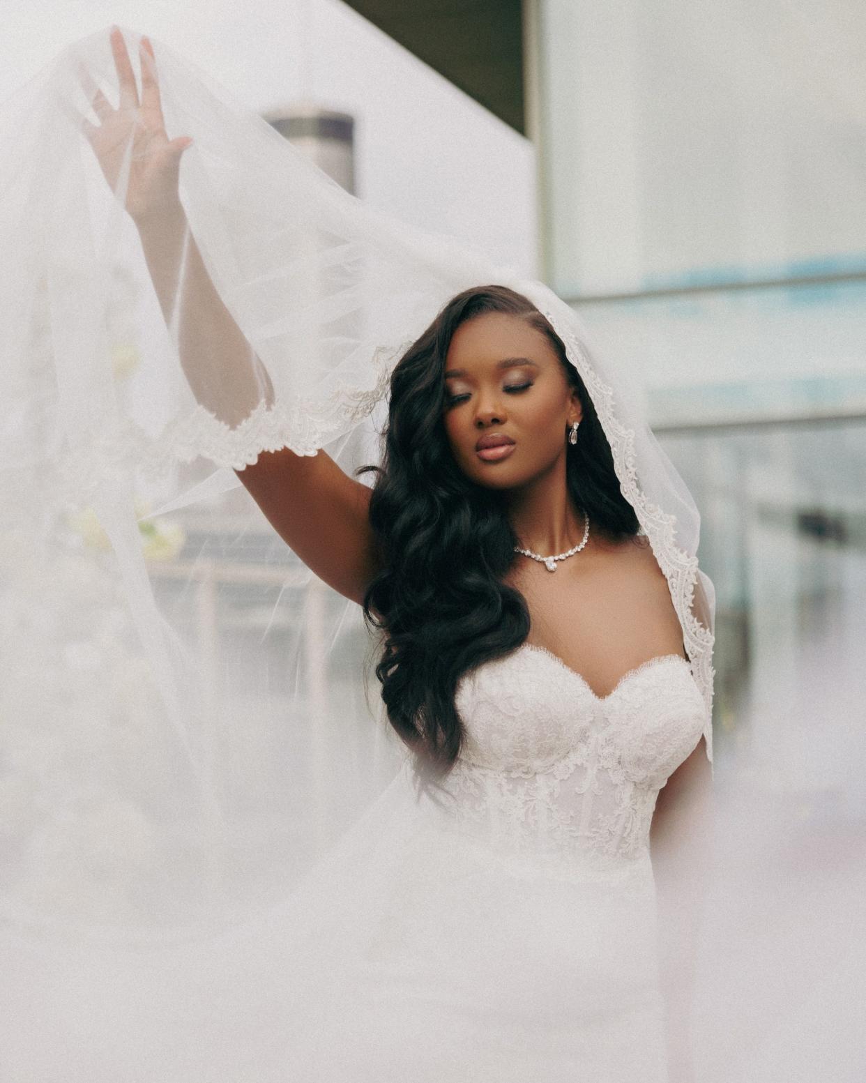 A bride's veil swoops around her.