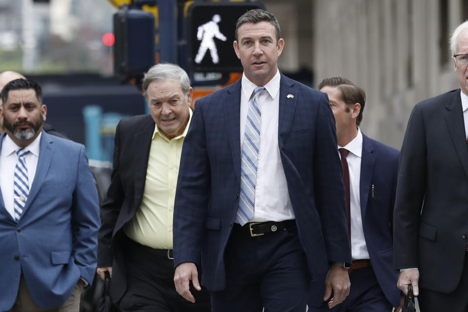 California Republican Rep. Duncan Hunter, center, walks towards federal court in front of his father, former Rep. Duncan L. Hunter, left, Tuesday, Dec. 3, 2019, in San Diego. Hunter said in a TV interview that aired Monday he plans to plead guilty to the misuse of campaign funds at a federal court hearing Tuesday in San Diego. (AP Photo/Gregory Bull)