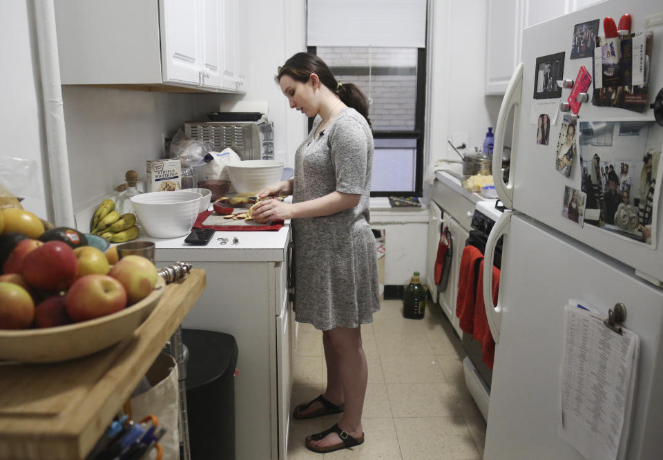In this Dec. 30, 2019, photo, Shoshana Blum, a 20-year-old junior at City College of New York, prepares Shabbat dinner at her family's home in New York. Any young Jews in the United States are searching for ways to cope following a string of anti-Semitic attacks that have them feeling targeted. (AP Photo/Jessie Wardarski)