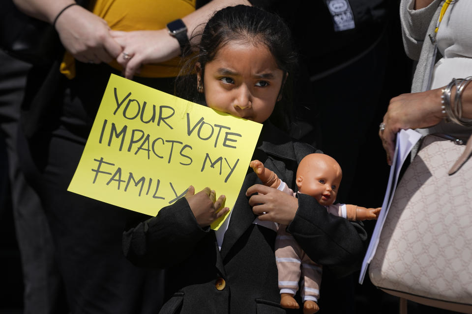 Evelyn Morales, 6, holds a sign during a news conference of the Tennessee Immigrant and Refugee Rights Coalition outside the state Capitol, Tuesday, March 19, 2024, in Nashville, Tenn. Members of the group came to the state Capitol to lobby legislators to vote against legislation that require local law-enforcement agencies to operate as if they have federal 287(g) agreements and a bill criminalizing transportation of undocumented immigrants. (AP Photo/George Walker IV)