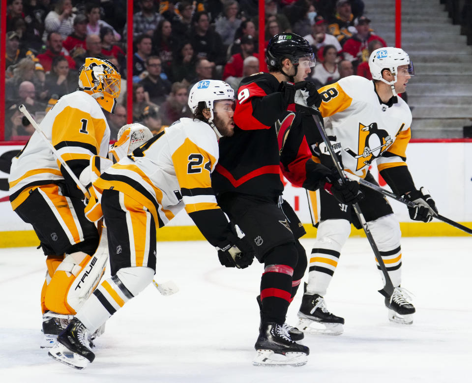 Pittsburgh Penguins defenseman Ty Smith (24) pushes against the back of Ottawa Senators center Josh Norris (9) during the second period of an NHL hockey game Wednesday, Jan. 18, 2023, in Ottawa, Ontario. (Sean Kilpatrick/The Canadian Press via AP)