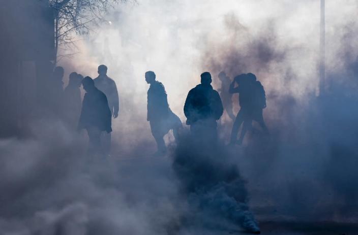 Opposition supporters stand in a cloud of tear gas as they clash with riot police in Pristina on November 18, 2015 (AFP Photo/Armend Nimani)