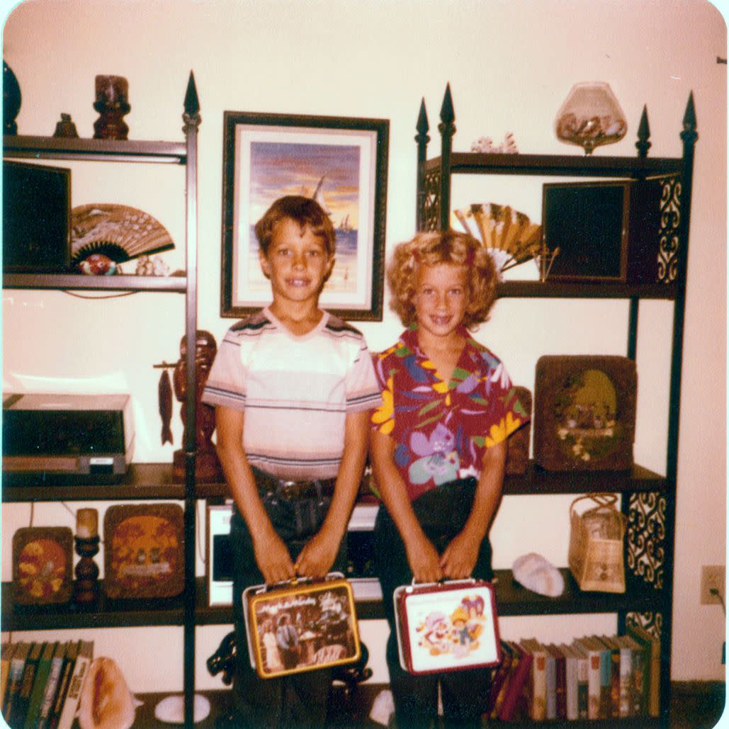 Two children posing for a picture holding their lunchboxes in the 1980s