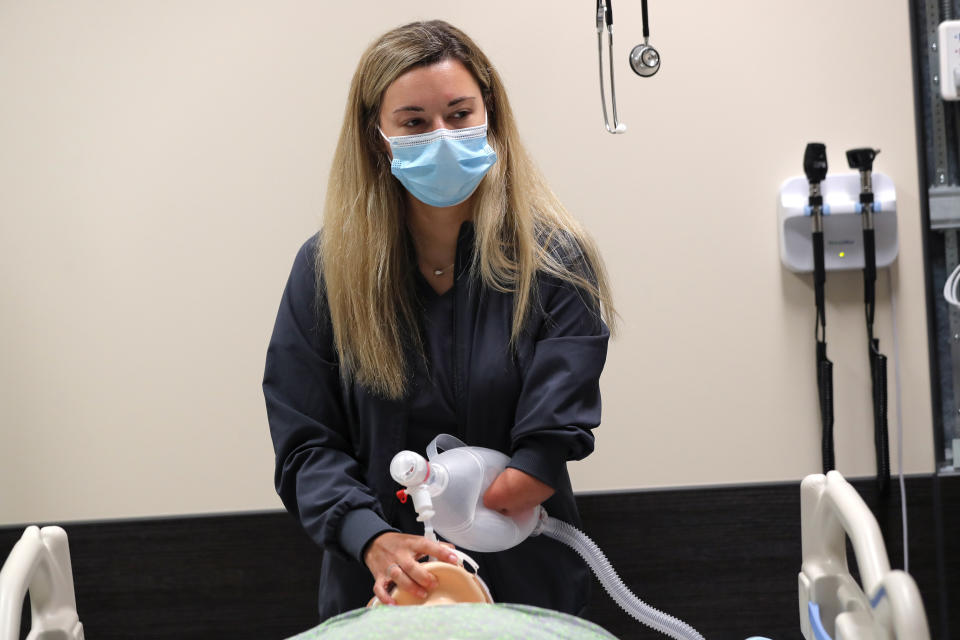 REMOVES REFERENCE OF AMPUTEE - Respiratory therapist Savannah Stuard, who was born without a left forearm, demonstrates her technique administering oxygen with an Ambu bag for treating COVID-19 patients inside a simulation lab, at Ochsner Medical Center in New Orleans, Tuesday, July 28, 2020. The Associated Press was not allowed into the hospital's COVID-19 intensive care unit. (AP Photo/Gerald Herbert)