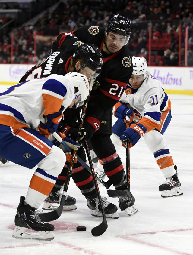 Ottawa Senators left wing Nick Paul (21) and right wing Connor Brown (28) try to get possession of the puck against New York Islanders defenseman Adam Pelech (3) and left wing Zach Parise (11) during the second period of an NHL hockey game Tuesday, Dec. 7, 2021, in Ottawa, Ontario. (Justin Tang/The Canadian Press via AP)
