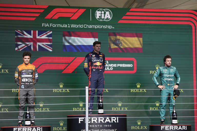 El piloto de Red Bull Max Verstappen en lo alto del podio junto a Landor Norris de McLaren y Fernando Alonso de Aston Martin tras el Gran Premio de Brasil en Interlagos el domingo 5 de octubre del 2023. (AP Foto/Andre Penner)