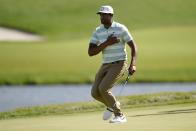 Tony Finau places the ball to his chest and reacts to his putt for par on the 17th green during the final round of the 3M Open golf tournament at the Tournament Players Club in Blaine, Minn., Sunday, July 24, 2022. (AP Photo/Abbie Parr)