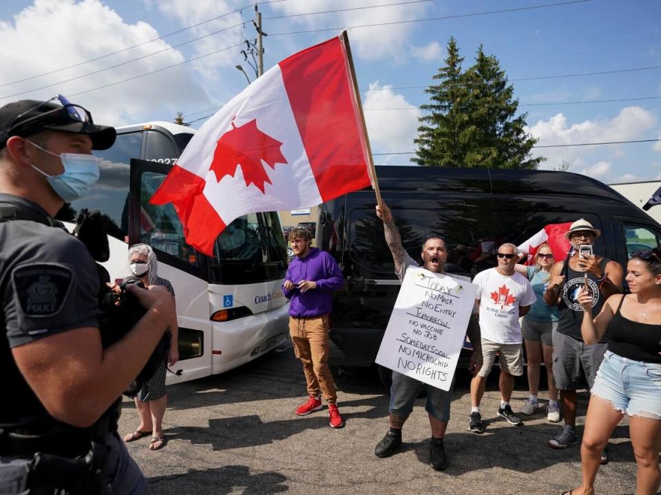 Protesters scream as police secure the property while Liberal Leader Justin Trudeau gets ready to announce green incentives towards climate change at a stop during the federal election campaign in Cambridge, Ont., on Aug. 29, 2021. (Nathan Denette/The Canadian Press - image credit)