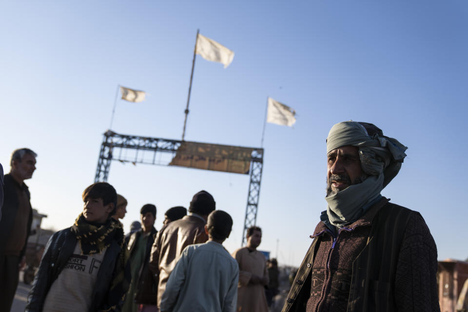 Afghan men stand near the Afghanistan-Iran border crossing of Islam Qala, on Wednesday, Nov. 24, 2021. Afghans are streaming across the border into Iran, driven by desperation after the near collapse of their country's economy following the Taliban's takeover in mid-August. In the past three months, more than 300,000 people have crossed illegally into Iran, according to the Norwegian Refugee Council, and more are coming at the rate of 4,000 to 5,000 a day. (AP Photo/Petros Giannakouris)