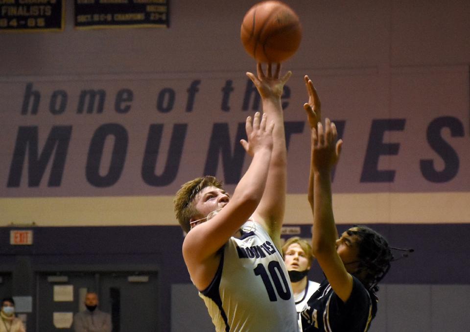 Little Falls Mountie John Shepardson (10) shoots over Utica Academy of Science Atom Donelious King Jr during the first half Tuesday in Little Falls.