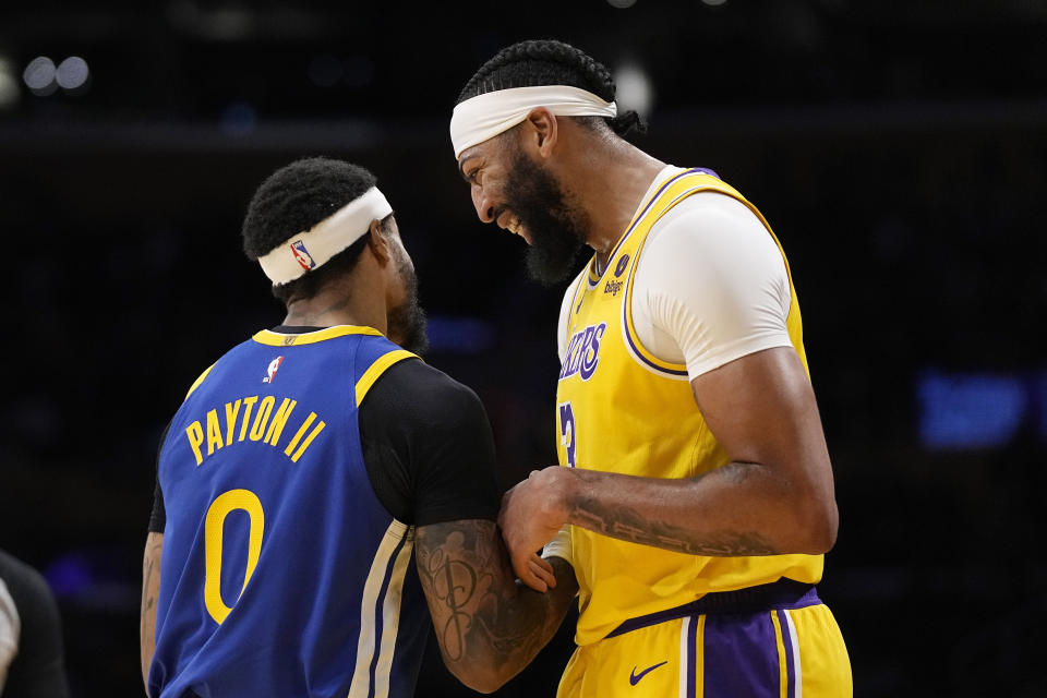 Golden State Warriors guard Gary Payton II, left, and Los Angeles Lakers forward Anthony Davis joke around during the first half of an NBA preseason basketball game Friday, Oct. 13, 2023, in Los Angeles. (AP Photo/Mark J. Terrill)