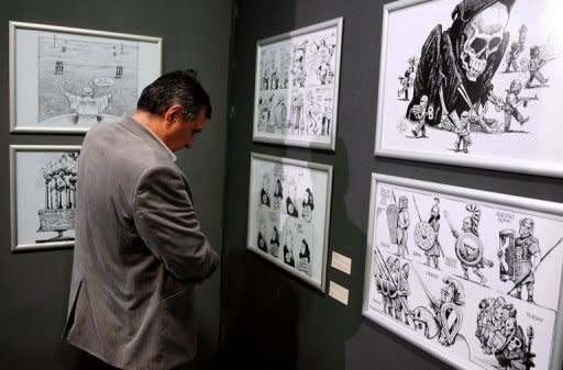 A visitor looks at drawings by Kallaugher during an exhibition at the National Museum of Contemporary Art in Bucharest. Kallaugher's satirical drawings for The Economist and US daily The Baltimore Sun are featured in an exhibition that opened this week at the National Museum of Contemporary Art in the Romanian capital