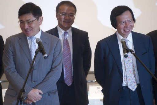 Co-chairman and Managing Directors of Sun Hung Kai Properties Raymond Kwok (L) and Thomas Kwok (R) react as they speak to the press after they were charged for corruption in Hong Kong. Two of Hong Kong's richest tycoons and a former senior official were charged with corruption in the biggest graft scandal the regional banking hub has seen