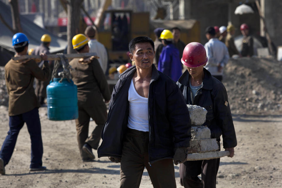 FILE - North Korean construction workers carry building materials in the Mansudae area of Pyongyang, North Korea, Oct. 11, 2011. As the war in Ukraine stretches into its seventh month, North Korea is hinting at its interest in sending construction workers to help rebuild Russian-occupied territories in the country's east.(AP Photo/David Guttenfelder, File)