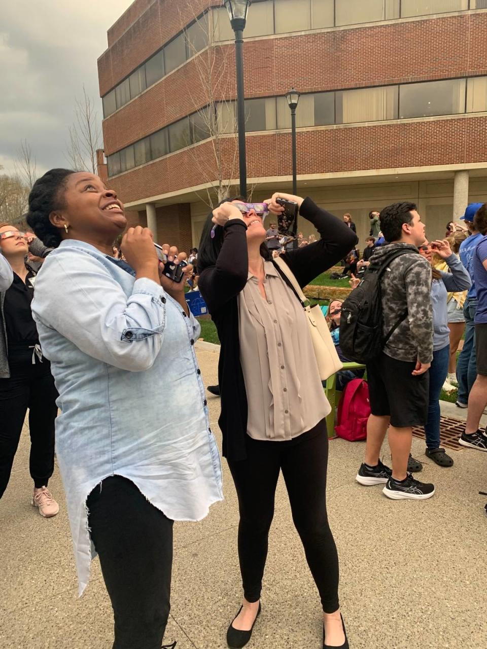 Casey Roley (left) and Michelle Bickerstaff (right) catch a glimpse of the solar eclipse in Lexington amid a cloudy sky on April 8, 2024. Kendall Staton