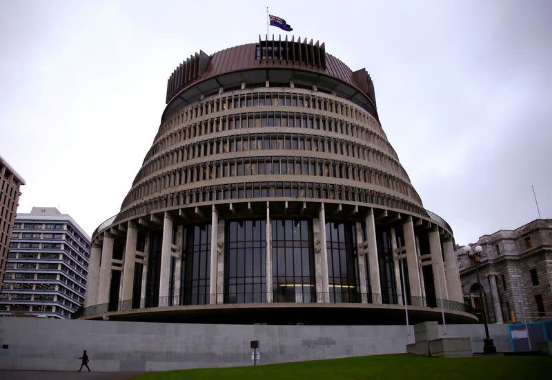 FILE PHOTO: A pedestrian walks past the New Zealand parliament building known as the Beehive in central Wellington, New Zealand