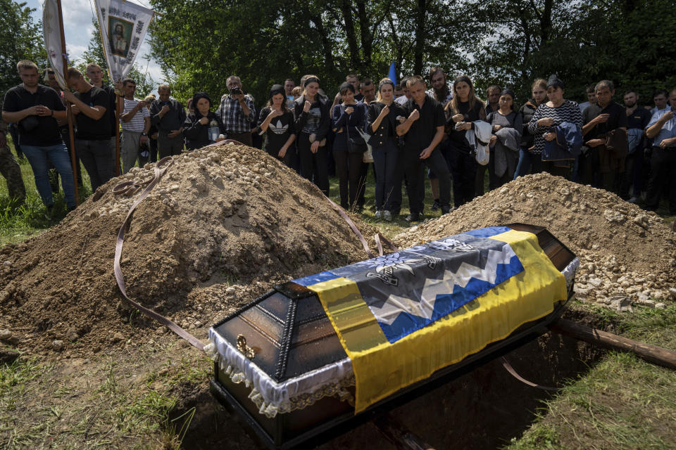 Relatives cross themselves during the funeral ceremony for Ukrainian serviceman Bohdan Kobylianskyi who was killed in Donbas, in Dusaniv, Ukraine, Saturday, July 22, 2023. (AP Photo/Evgeniy Maloletka)