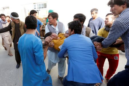 Men carry an injured person at a hospital after a suicide attack in Kabul, Afghanistan July 23, 2016. REUTERS/Mohammad Ismail