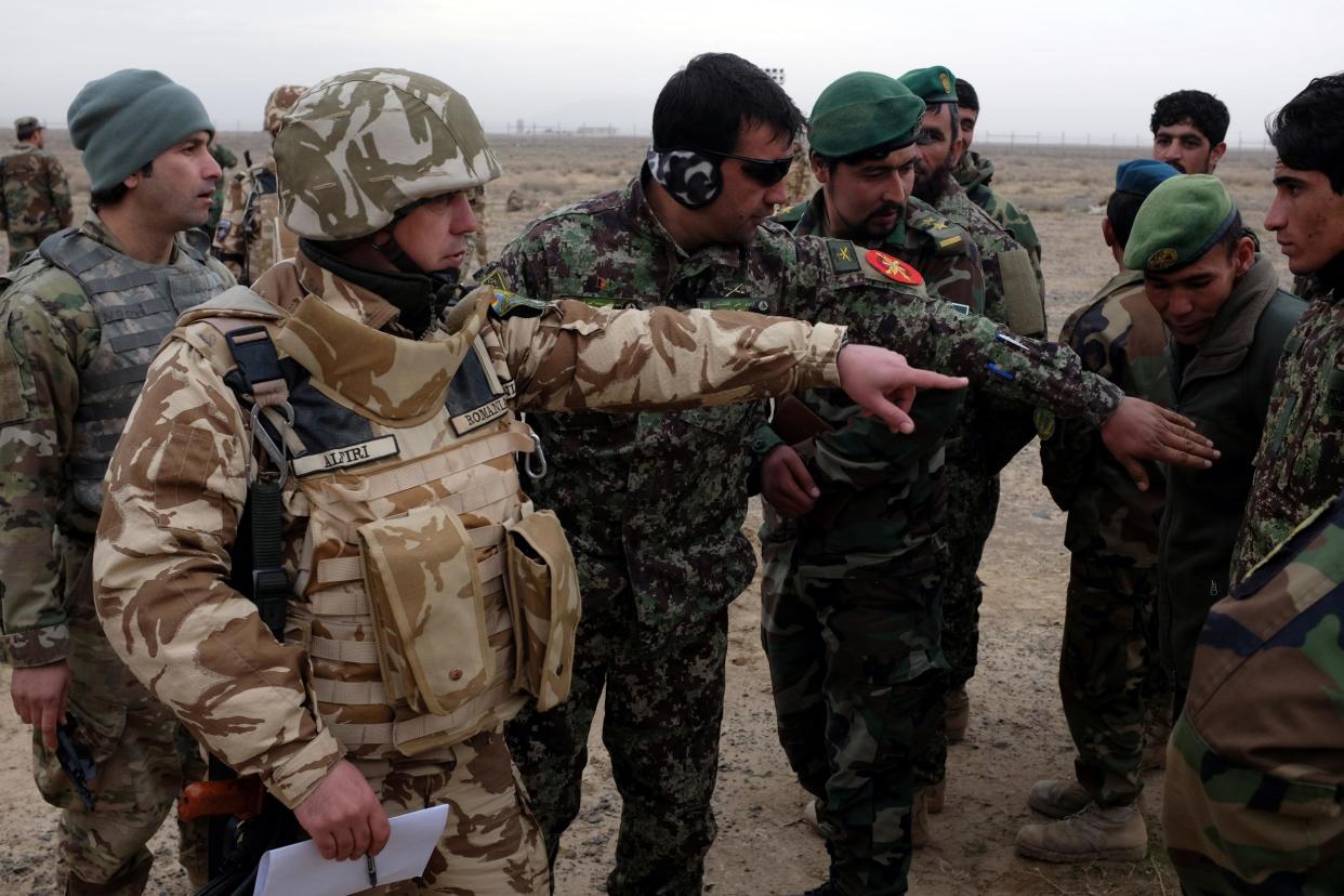 A Romanian military adviser speaks with Afghan troops during a live-fire artillery exercise outside Kandahar Air Field in this file photo from 15 February 2017: REUTERS