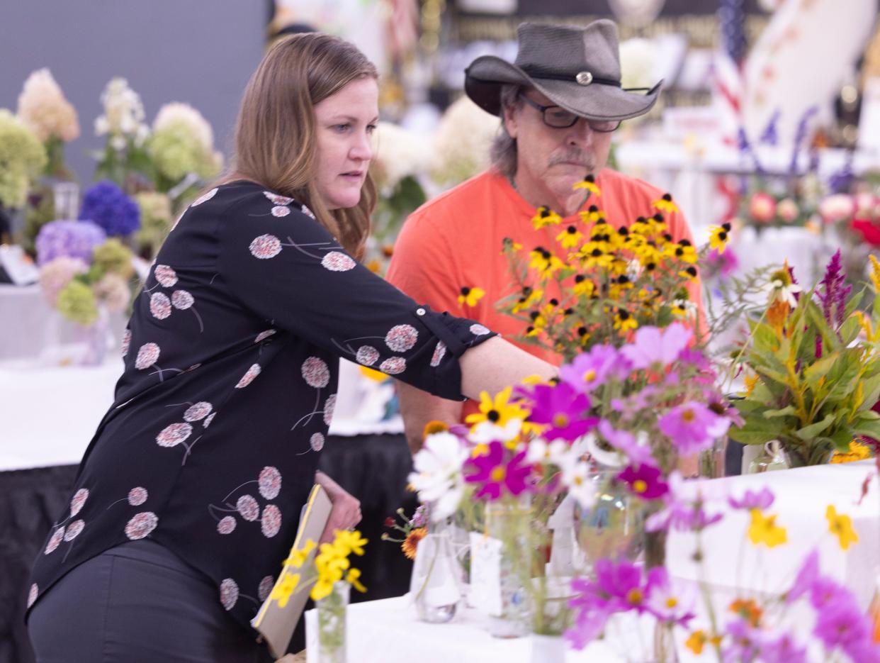 Liz Phipps, left, and Neal Perkins, judge cut flowers and floral arrangements on Tuesday, the first day of the 2024 Stark County Fair in Canton.