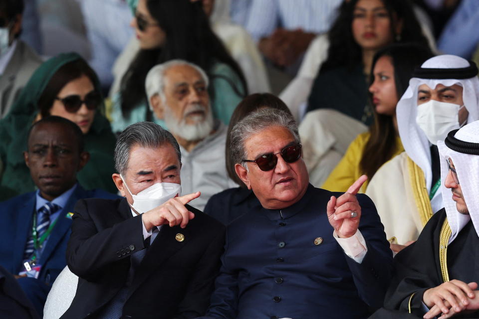 Pakistan's Foreign Minister Shah Mahmood Qureshi and Chinese Foreign Minister Wang Yi, gesture as they attend Pakistan Day military parade in Islamabad, Pakistan, March 23, 2022. REUTERS/Saiyna Bashir