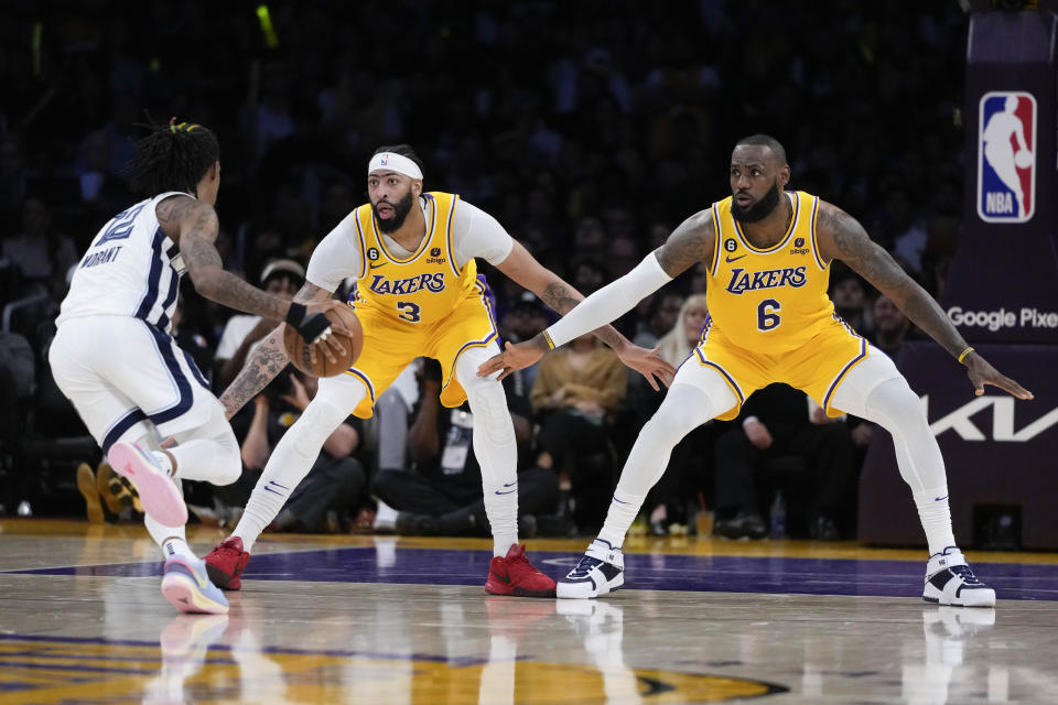 Los Angeles Lakers' LeBron James (6) and Anthony Davis (3) defend against Memphis Grizzlies' Ja Morant (12) during the first half in Game 6 of a first-round NBA basketball playoff series Friday, April 28, 2023, in Los Angeles. (AP Photo/Jae C. Hong)