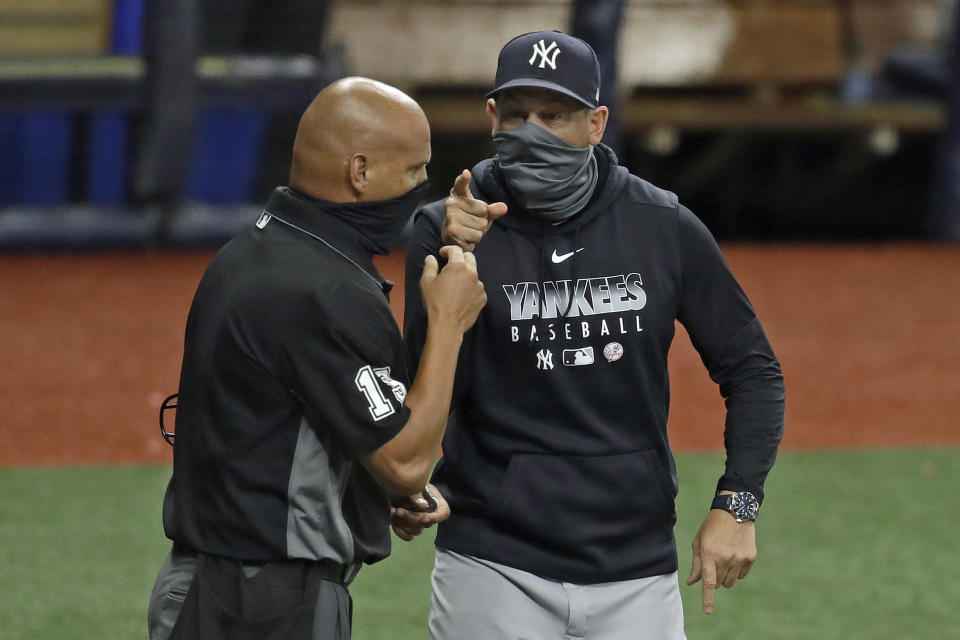 New York Yankees manager Aaron Boone, right, argues with home plate umpire Vic Carapazza during the fifth inning of the second game of a doubleheader baseball game against the Tampa Bay Rays Saturday, Aug. 8, 2020, in St. Petersburg, Fla. The Yankees were upset when Rays relief pitcher Andrew Kittredge threw an inside pitch to DJ LeMahieu. Boone was eventually ejected. (AP Photo/Chris O'Meara)