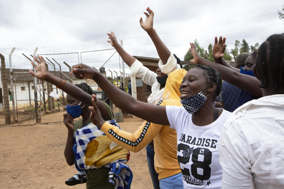 Female prsioners wave goodbye to their fellow inmates following their release from Chikurubi prison on the outskirts of Harare, Saturday, April 17, 2021. Zimbabwe began the release of about 3,000 prisoners under a presidential amnesty aimed at easing congestion and minimizing the threat of COVID-19 across the country's overcrowded jails. (AP Photo/Tsvangirayi Mukwazhi)