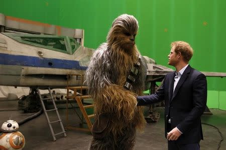 Britain's Prince Harry meets Chewbacca during a visit to the Star Wars film set at Pinewood Studios near Iver Heath, west of London, Britain, April 19, 2016. REUTERS/Adrian Dennis/Pool