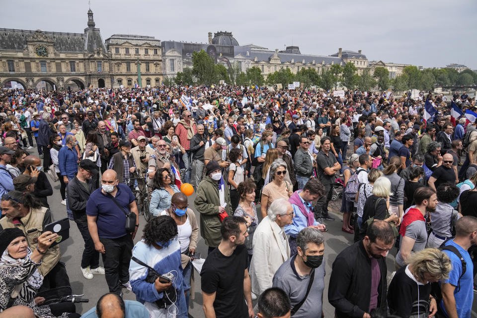 Anti-vaccine protesters march during a rally in Paris, Saturday, July 17, 2021. Tens of thousands of people protested across France on Saturday against the government's latest measures to curb rising COVID-19 infections and drive up vaccinations in the country. The Louvre museum in the background. (AP Photo/Michel Euler)