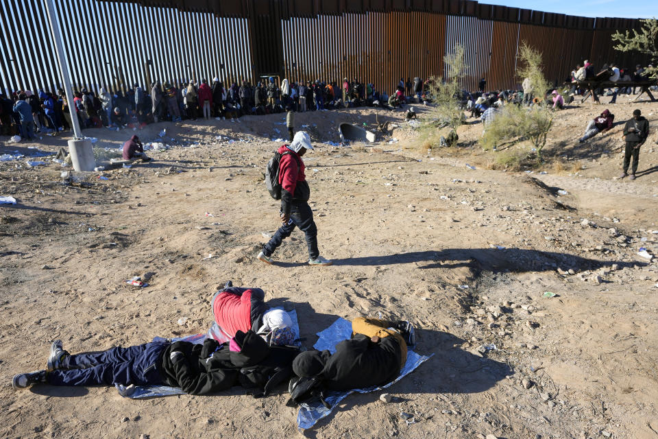 Hundreds of migrants gather along the border after breaking through gaps in the border wall Tuesday, Dec. 5, 2023, in Lukeville, Ariz. (AP Photo/Ross D. Franklin)