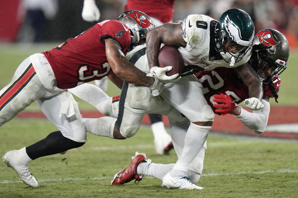 Philadelphia Eagles' D'Andre Swift (0) is tackled by Tampa Bay Buccaneers' Ryan Neal (23) and Antoine Winfield Jr. (31) during the second half of an NFL football game, Monday, Sept. 25, 2023, in Tampa, Fla. (AP Photo/Chris O'Meara)