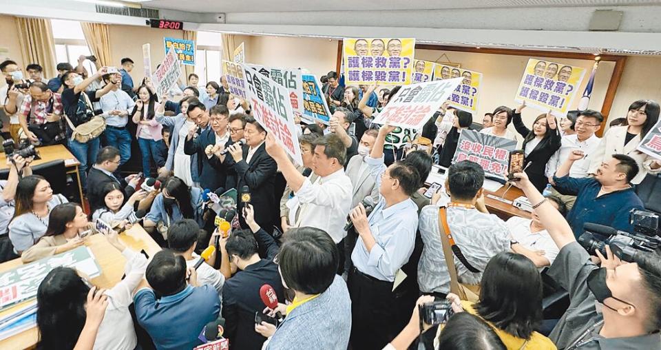 立法院內政委員會4日審查《公職人員選舉罷免法修正草案》，民進黨立委罷占主席台，藍綠各舉標語表達立場，場面一片混亂。（姚志平攝）