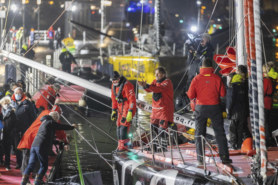 France's Yannick Bestaven, center right, gestures, after winning the Vendee Globe solo around-the-world sailing race, in Les Sables-d'Olonne, western France, early Thursday, Jan.28, 2021. Frenchman Charlie Dalin crossed the line first Wednesday but Bestaven was getting 10 hours, 15 minutes for helping in the search and rescue of another competitor off Cape Horn last November. (AP Photo/Yohan Bonnet)