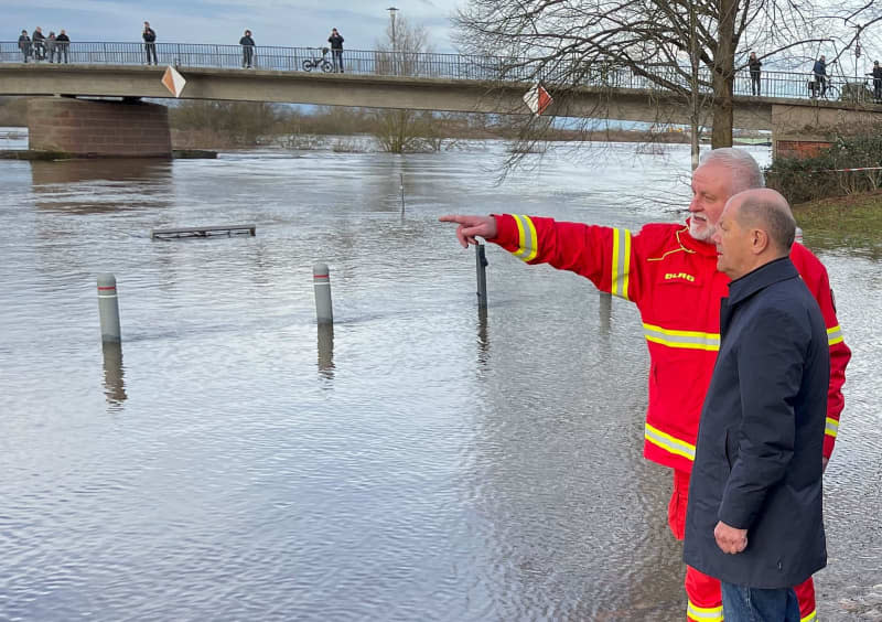 Germany's Chancellor Olaf Scholz (R) talks to Karsten Hauschild from the DLRG in the flood area at the confluence of the Weser and Aller rivers. Scholz took a sightseeing flight in an air force helicopter to gain an impression of the flooding situation in the north of Lower Saxony. Arne von Brill/dpa