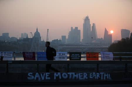 A commuter walks along Waterloo Bridge, which is being blocked by climate change activists, during the Extinction Rebellion protest in London, Britain April 17, 2019. REUTERS/Hannah McKay