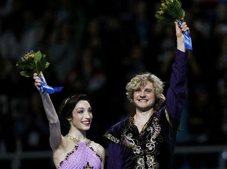 Meryl Davis and Charlie White of the U.S. celebrate in first place on the podium during the Figure Skating Ice Dance Free Dance Program at the Sochi 2014 Winter Olympics, February 17, 2014. REUTERS/Alexander Demianchuk