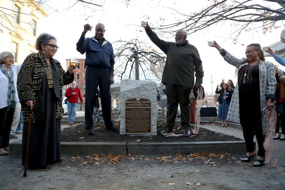 Valerie Cunningham, left, historian and founding member of the Black Heritage Trail of New Hampshire, Black Heritage Trail President-elect Dwight Davis, board member the Rev. Bob Thompson and Executive Director JerriAnne Boggis offer cheers to the newly unveiled Pomp and Candace Spring marker in Portsmouth Thursday, Nov. 18, 2021.