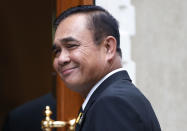 Thailand's Prime Minister Prayuth Chan-ocha smiles as he talks reporters before meeting at government house in Bangkok, Thailand, Thursday, June 6, 2019. Thailand's Parliament elected 2014 coup leader Prayuth Chan-ocha as prime minister in a vote Wednesday that helps ensure the military's sustained dominance of politics since the country became a constitutional monarchy nearly nine decades ago. (AP Photo/Sakchai Lalit)