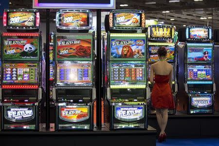 A visitor tries a slot machine during the Global Gaming Expo Asia in Macau May 20, 2014. REUTERS/Tyrone Siu