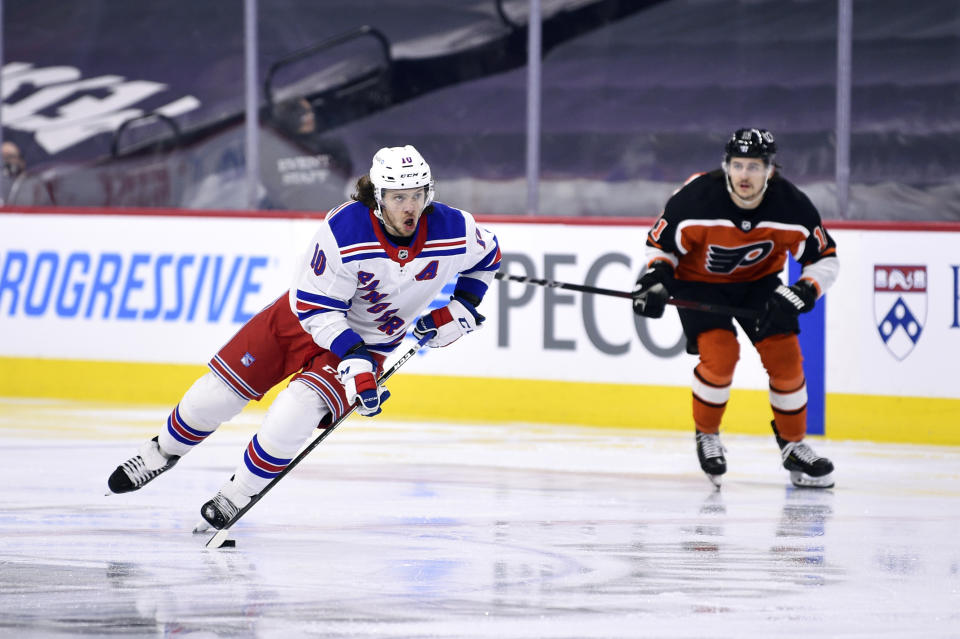 New York Rangers' Artemi Panarin skates up ice with eh puck past Philadelphia Flyers' Travis Konecny during the second period of an NHL hockey game, Saturday, March 27, 2021, in Philadelphia. (AP Photo/Derik Hamilton)