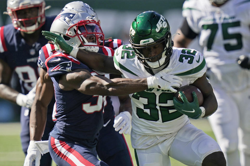 New York Jets' Michael Carter, right, runs the ball during the second half of an NFL football game against the New England Patriots, Sunday, Sept. 19, 2021, in East Rutherford, N.J. (AP Photo/Frank Franklin II)