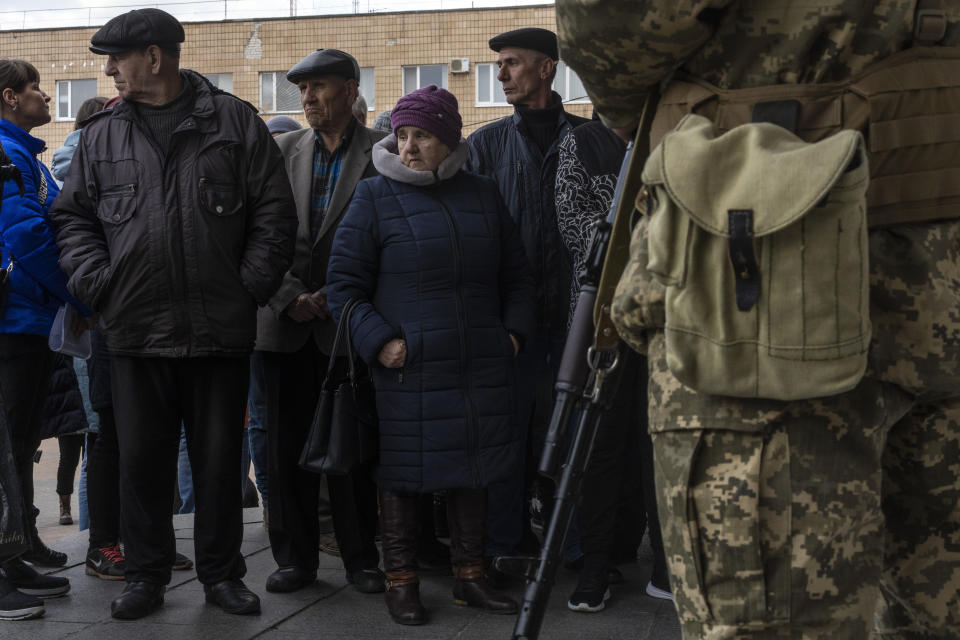 Displaced people wait in line outside the District Department of the State Migration Service to receive food and a place to sleep, in Brovary, on the outskirts of Kyiv, Ukraine, Tuesday, March 29, 2022. (AP Photo/Rodrigo Abd)