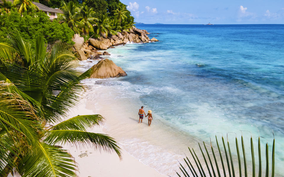 Anse Source d'Argent, La Digue Seychelles, a young couple of men and women on a tropical beach during a luxury vacation in Seychelles. Tropical beach Anse Source d'Argent, La Digue Seychelles