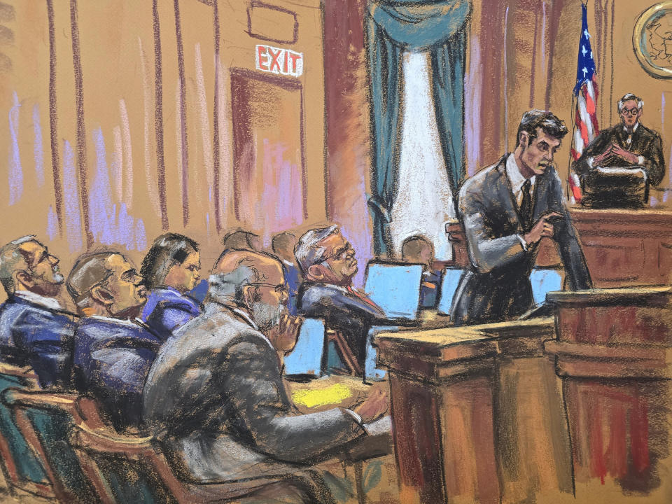 In this courtroom sketch, Wednesday, July 10, 2024, attorney Adam Fee, standing right, presents closing arguments for Sen. Robert Menendez, seated center, in Manhattan federal court, in New York. (Jane Rosenberg via AP)