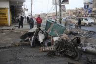 Residents inspect the site of a bomb attack in Baghdad, January 14, 2014. Four car bombs killed at least 25 people in Shi'ite Muslim districts of Baghdad on Monday, police said, in violence that coincided with a visit to the Iraqi capital by U.N. Secretary-General Ban Ki-moon. Although no group claimed responsibility, the bombings appeared to be part of a relentless campaign by al Qaeda-linked Sunni Muslim militants to undermine Prime Minister Nuri al-Maliki's Shi'ite-led government. (REUTERS/Wissm al-Okili)