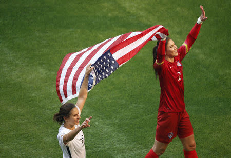 Jul 5, 2015; Vancouver, British Columbia, CAN; United States midfielder Carli Lloyd (10) and United States goalkeeper Hope Solo (1) celebrate with an American flag after defeating Japan in the final of the FIFA 2015 Women's World Cup at BC Place Stadium. Credit: Erich Schlegel-USA TODAY Sports