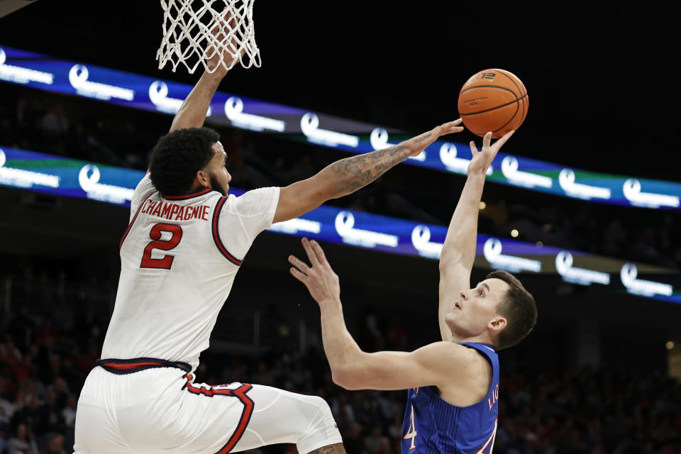 Kansas forward Mitch Lightfoot (44) shoots while being defended by St. John's guard Julian Champagnie (2) during the first half of an NCAA college basketball game Friday, Dec. 3, 2021, in Elmont, N.Y. (AP Photo/Adam Hunger)